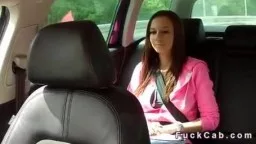 Junge Frau in pinker Jacke mit Sicherheitsgurt auf Rücksitz eines Taxis